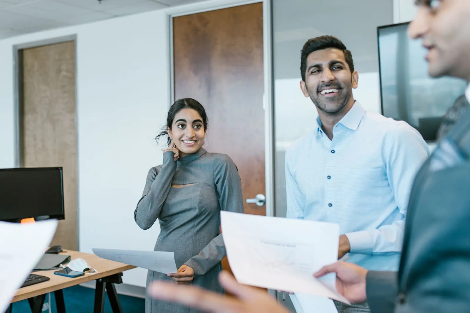 Colleagues talking through documents during a team meeting