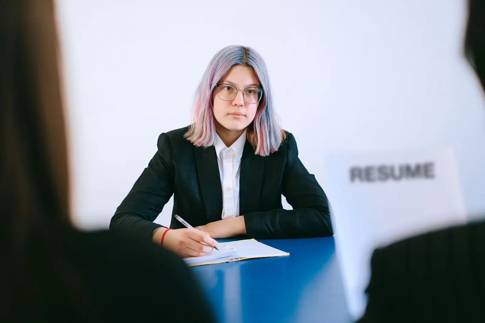 A candidate in a suit preparing notes during a job interview