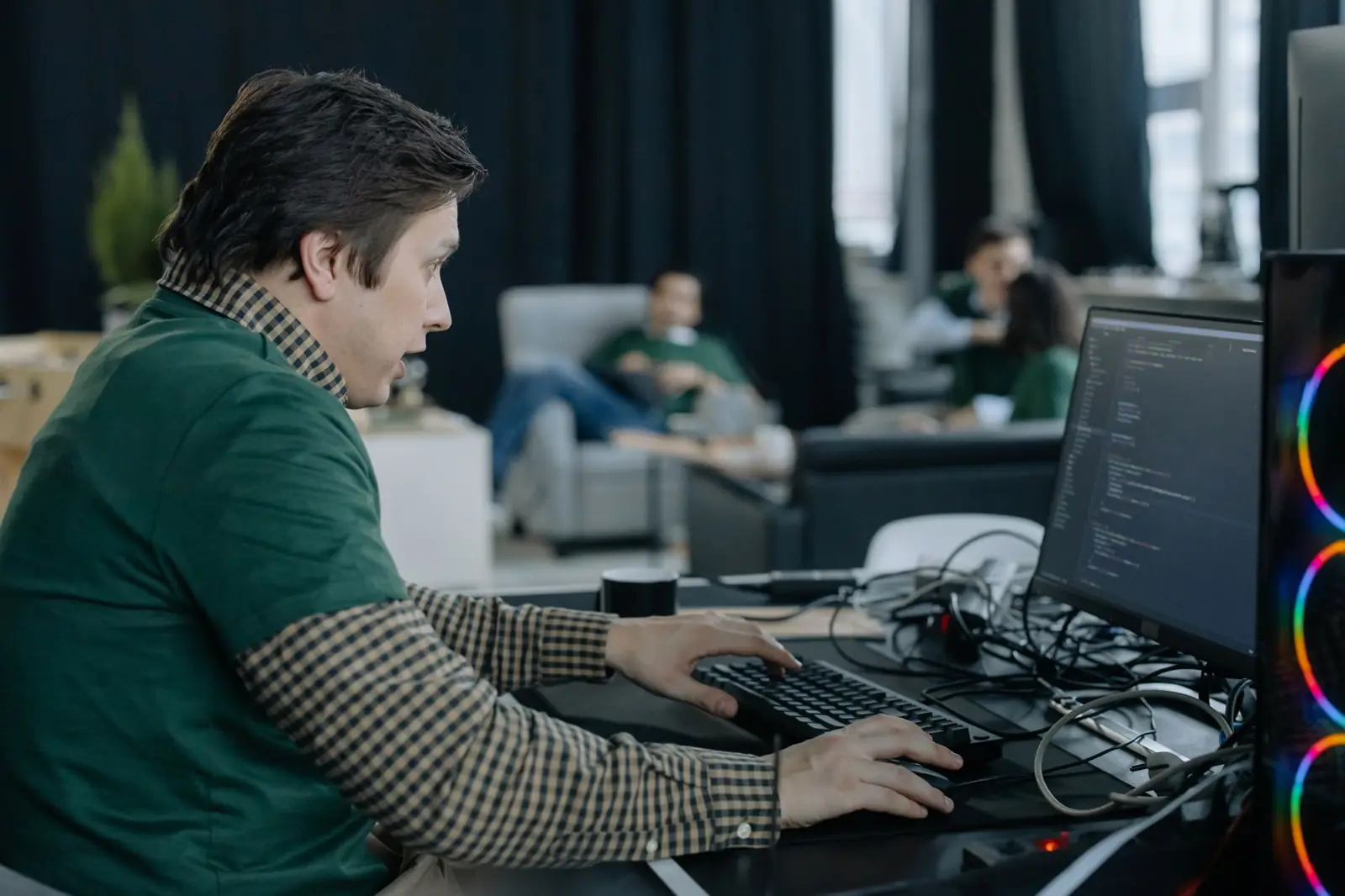 A software developer working at a multi-screen desk setup