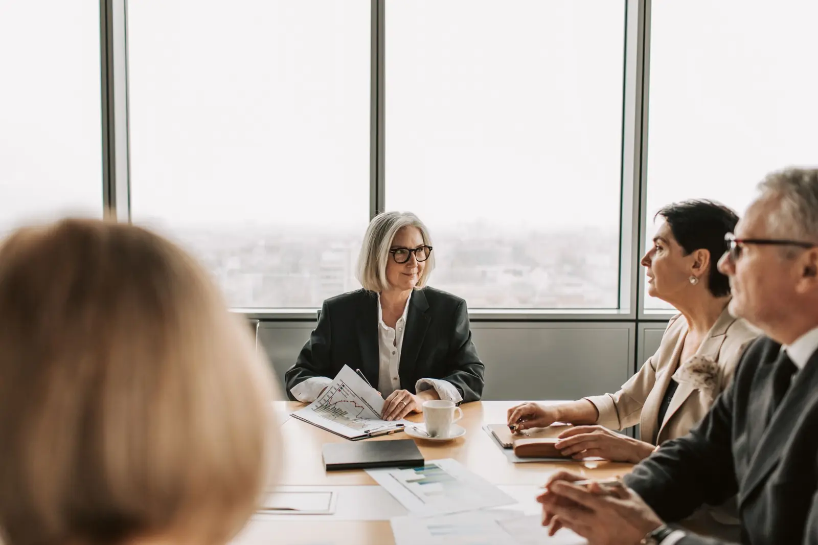 A senior leadership team in discussion around a boardroom table