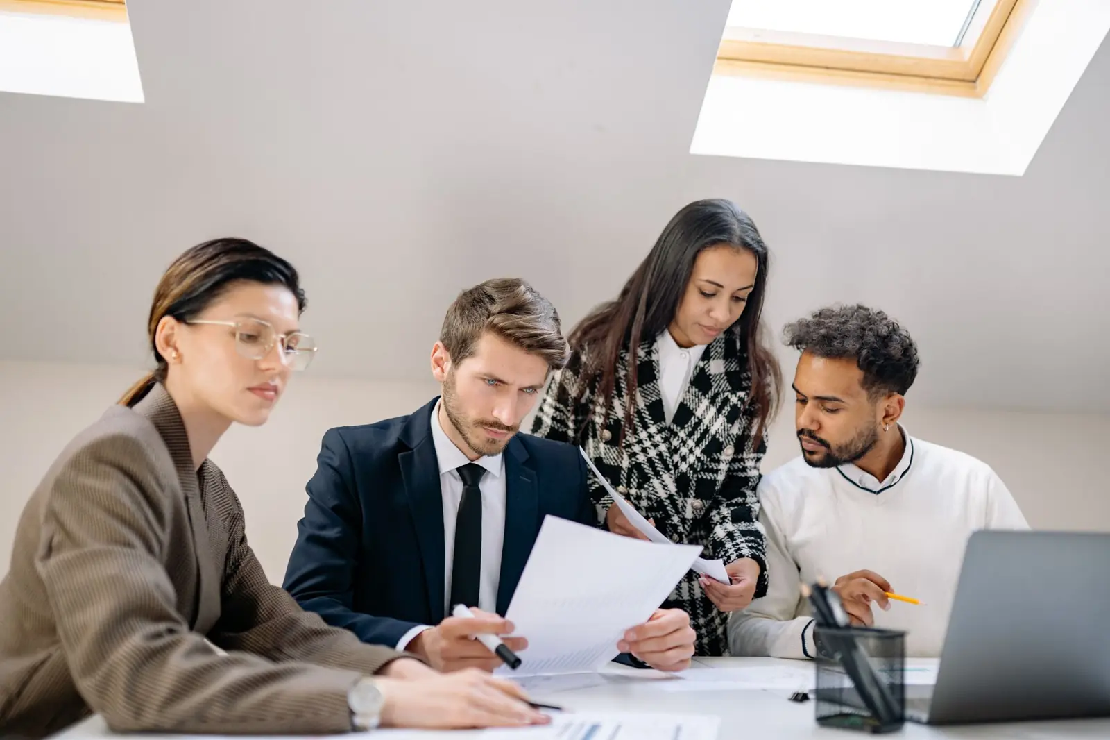 A hiring team reviewing candidate documents together at a shared desk